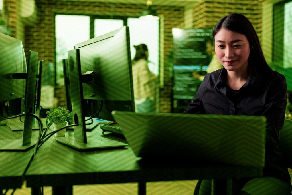 Young technology professional woman sitting at a computer taking an online training course.